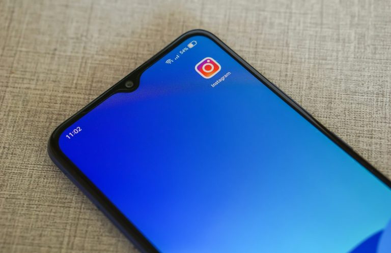 Smartphone mit einem blauen Hintergrund und einer App-Ikone in der oberen Ecke.