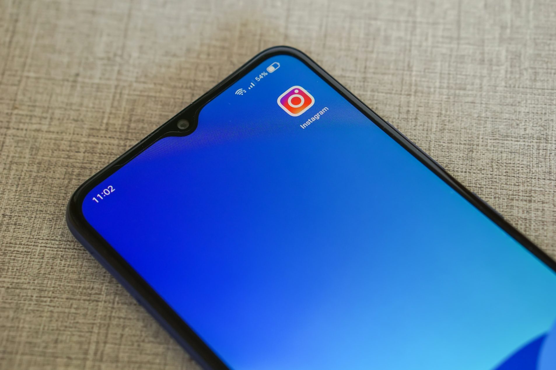 Smartphone-Bildschirm mit blauer Hintergrundfarbe und einer App-Verknüpfung.